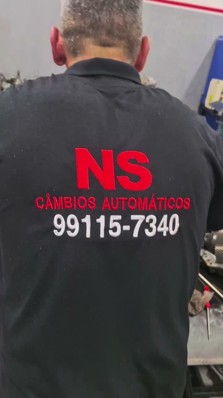 Mecânico da NS Câmbio Automático com camiseta da oficina durante o serviço